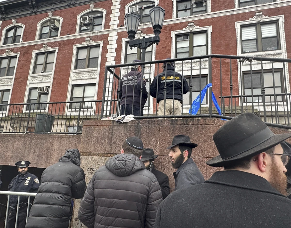 City inspectors and police offers outside the Brooklyn borough, NY, headquarters of the Chabad movement.(AP )