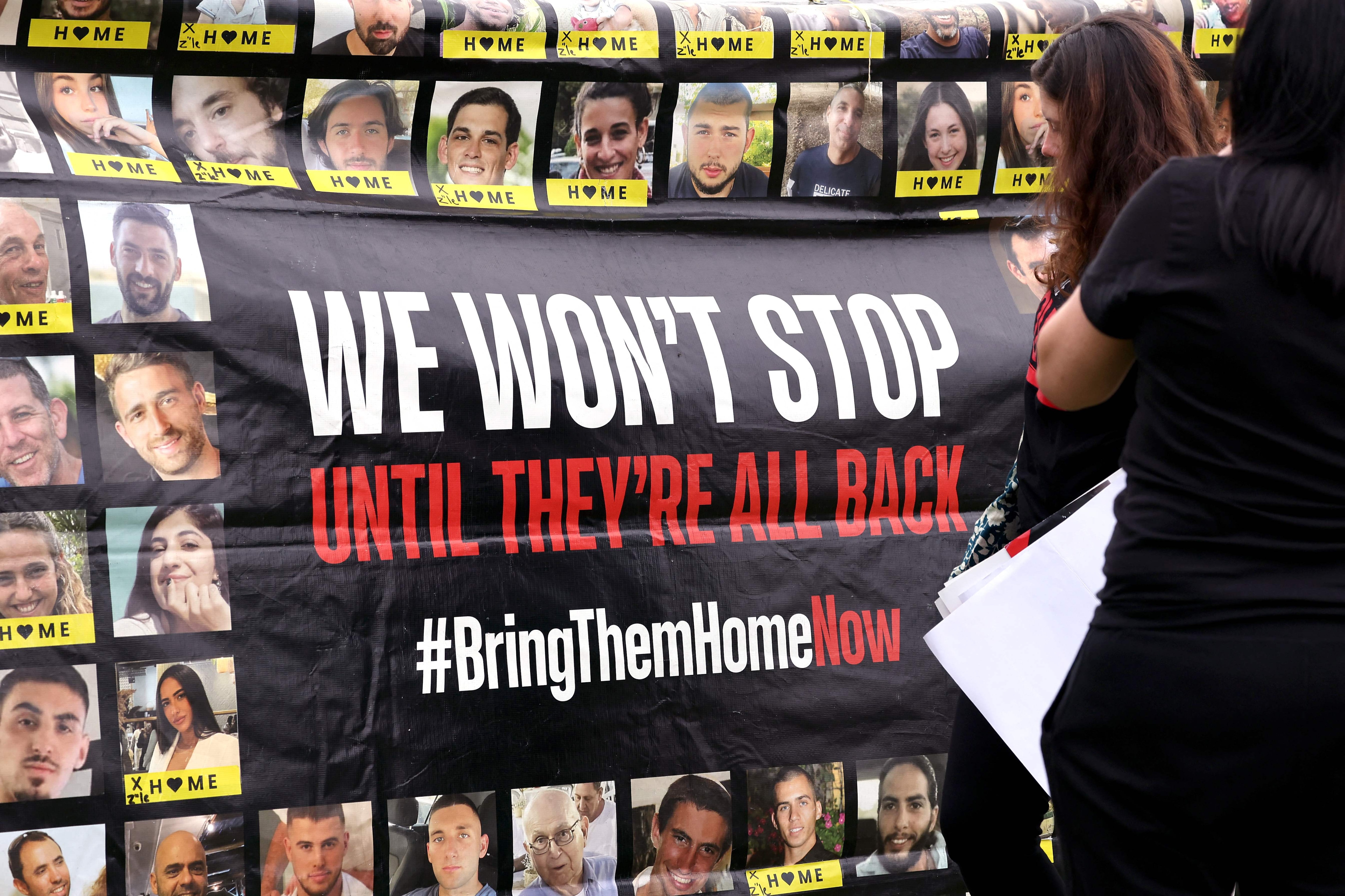 Members of the Australian Jewish community hold a banner bearing the portraits of Israelis held hostage in the Gaza during a rally in Sydney(AFP)